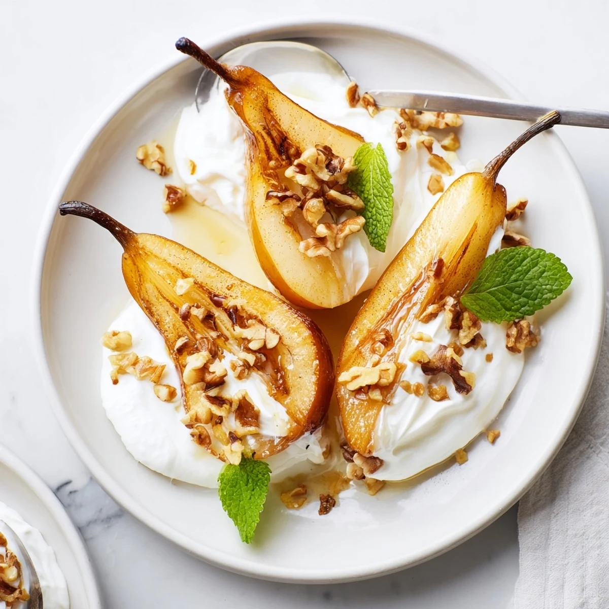 Warm, glistening Roasted Pears with cinnamon, walnuts, and creamy Greek yogurt—a beautiful dessert.