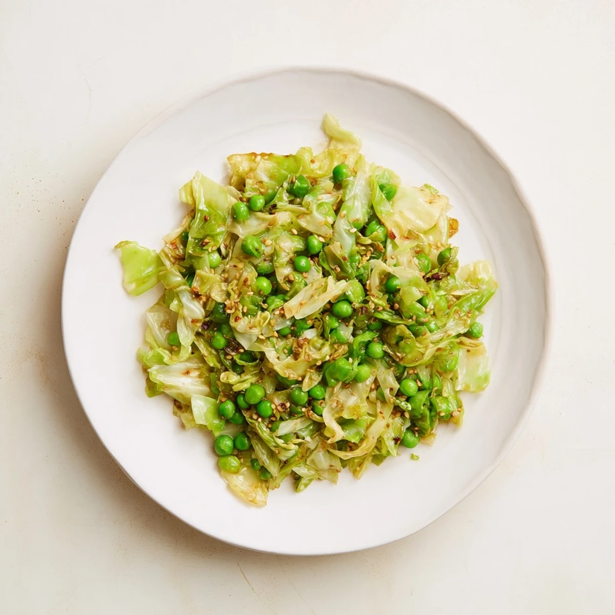 Steaming Cabbage Stir-Fry with garlic and peas, glistening with savory sauce, ready to serve.