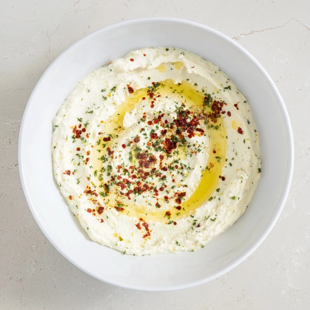 A vibrant close-up of the whipped ricotta dip, featuring drizzles of spicy hot honey.
