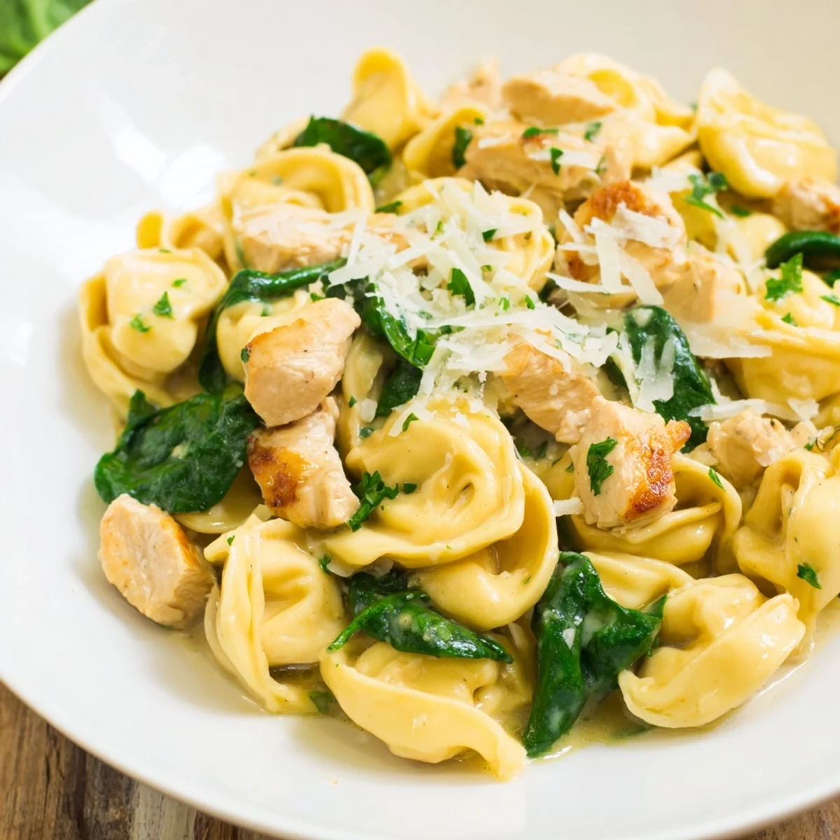 Creamy Chicken and Spinach Tortellini, a golden-sauced pasta dish garnished with fresh parsley.
