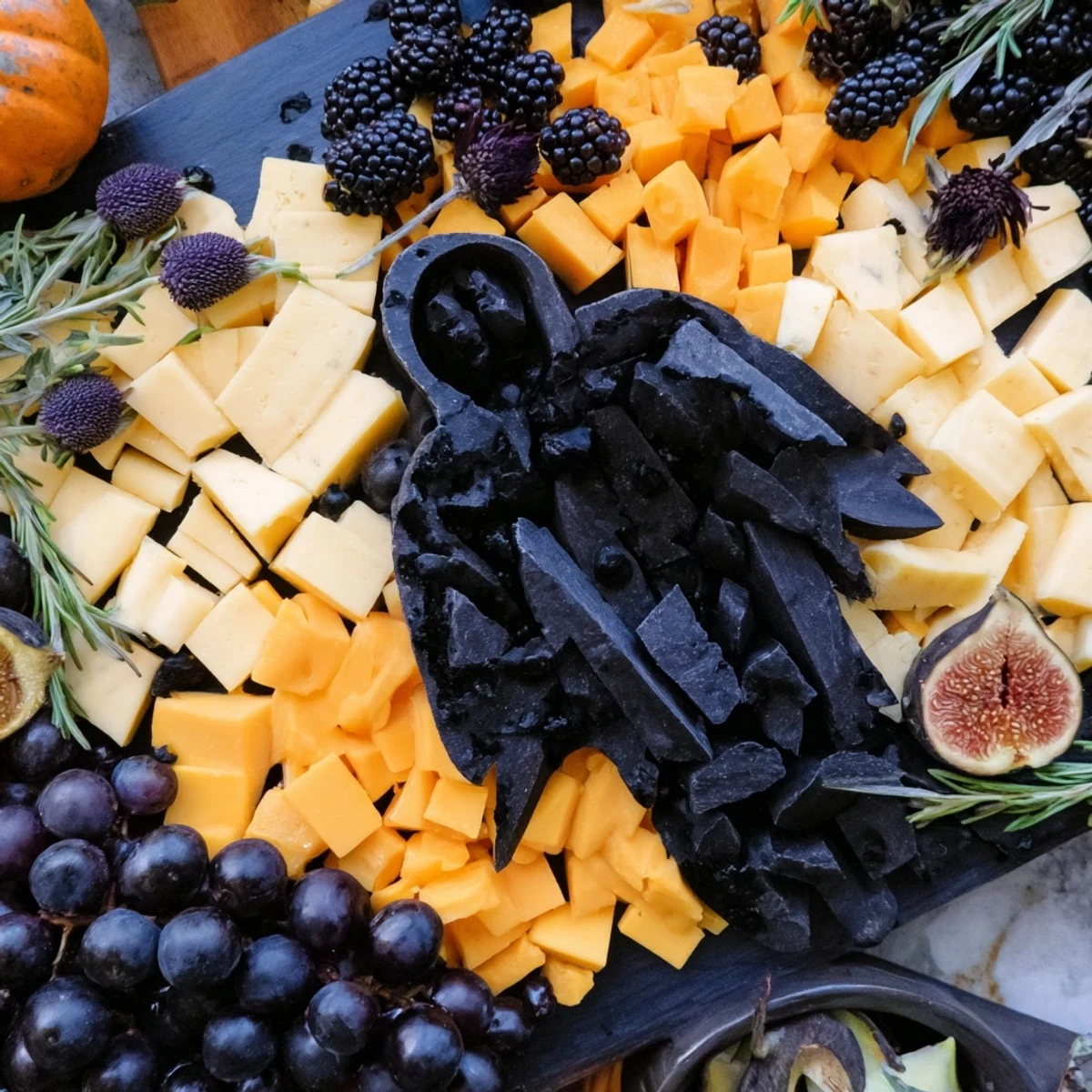 Ghostly Halloween charcuterie board with dark cheese, grapes, and spooky edible artistry.