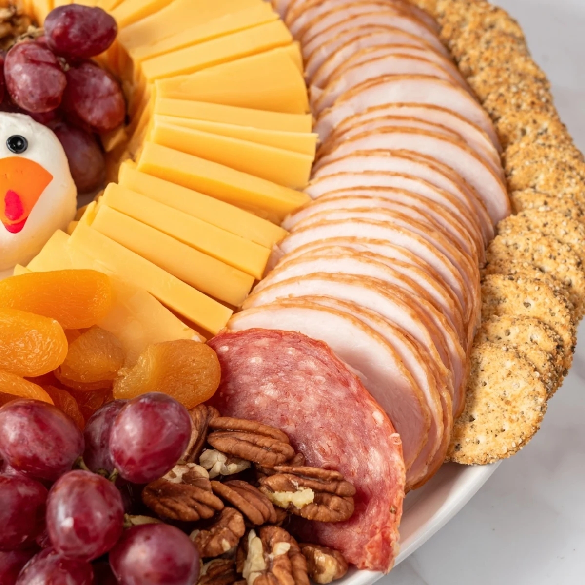 Thanksgiving appetizer, the "Turkey Tail Fan," features artfully arranged meats and cheeses for a feast.