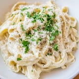 A bowl of fresh Cottage Cheese Alfredo Sauce, garnished with parsley, ready for a satisfying Italian meal.