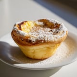Warm, creamy custard filling inside flaky phyllo cups: a classic Portuguese egg tart recipe.