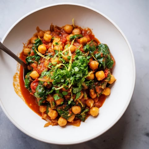 A vibrant chickpea and spinach curry simmering in a spiced tomato sauce.  