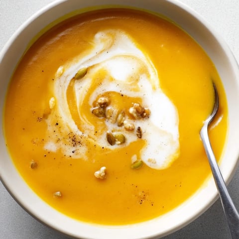 Creamy Butternut Squash Soup garnished with herbs, showcasing its luscious, velvety texture.