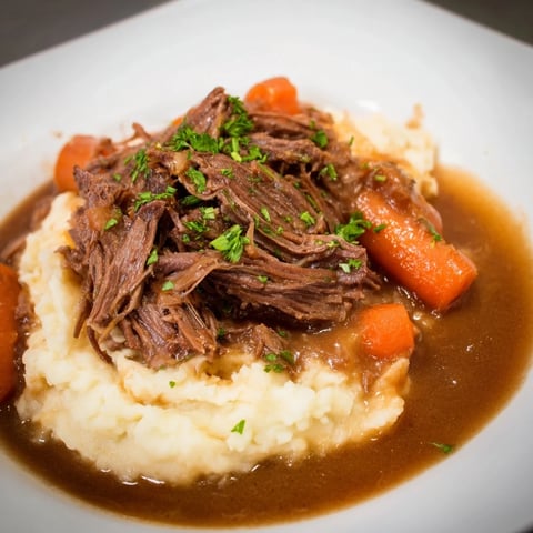Tender slow cooker pot roast with vegetables and creamy mashed potatoes, ready to serve.