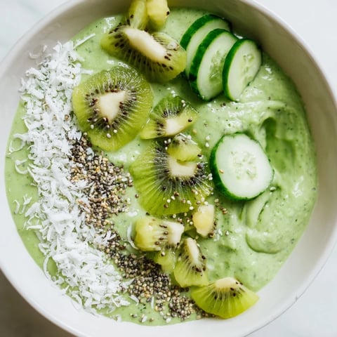 Creamy Green Smoothie Bowl with kale, kiwi, and avocado, topped with vibrant kiwi slices and crunchy hemp seeds.