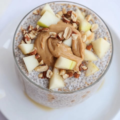Creamy Apple-Chia Pudding with peanut butter swirled, layered beautifully with apple slices and chopped peanuts, ready to eat.