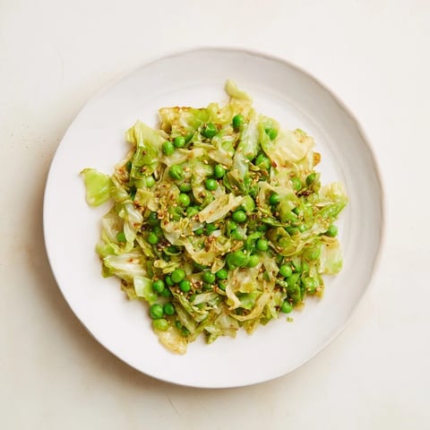 Steaming Cabbage Stir-Fry with garlic and peas, glistening with savory sauce, ready to serve.