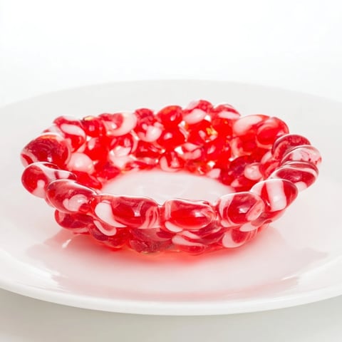 Melted, shiny peppermint candies forming a vibrant No-Bake Peppermint Candy Bowl, ready for festive treats.