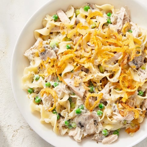Golden-brown creamy tuna noodle casserole with crispy onion topping, ready to serve and enjoy.