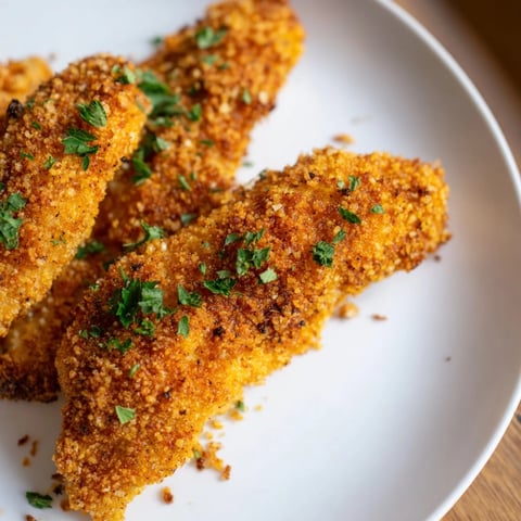 Golden, crispy Air Fryer Festive Chicken Tenders, ready to dip in cranberry sauce or mustard.