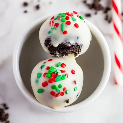 Festive Simplified Christmas Oreo Truffles coated in white chocolate and colorful sprinkles, ready to serve.