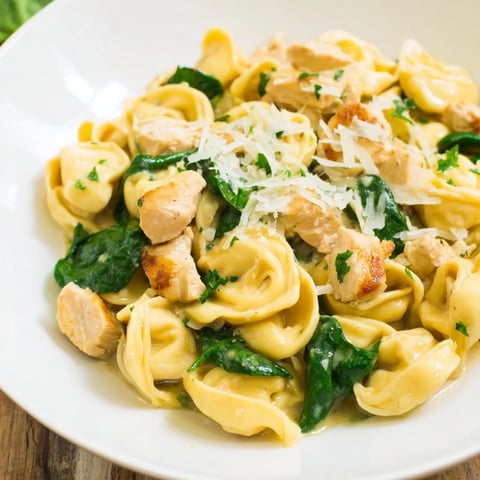 Creamy Chicken and Spinach Tortellini, a golden-sauced pasta dish garnished with fresh parsley.