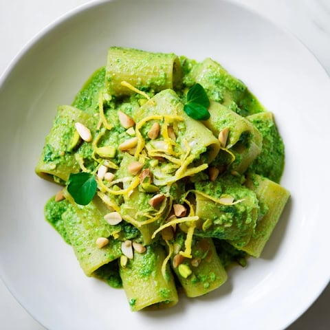 A bowl of creamy Green Pea & Spinach Elf Green Protein Pasta, topped with lemon zest.