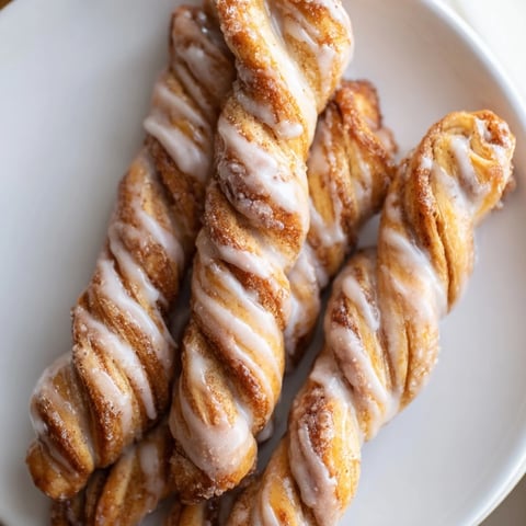 Air-Fryer Cinnamon Roll Twists glistening with glaze, warm from the air fryer, a perfect breakfast.