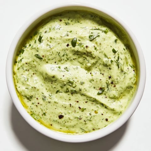 Creamy Green Goddess Dip, vibrant and green, ready to scoop with crunchy vegetables or chips.