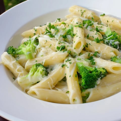 Close-up view of creamy cream cheese garlic pasta, a dish with broccoli and Parmesan.