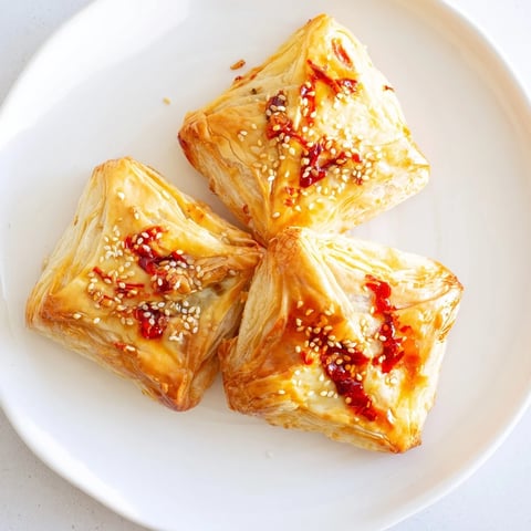 Golden, flaky Chili Crisp Honey Brie Bites, baked and drizzled, offering sweet and spicy flavors perfect for sharing.