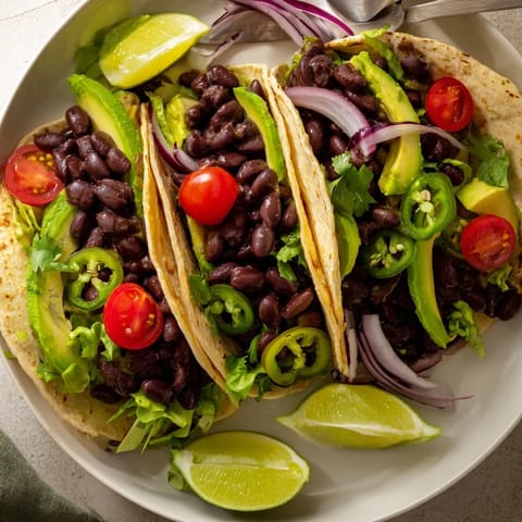 Creamy avocado and savory black bean tacos, bursting with colorful, fresh toppings.  