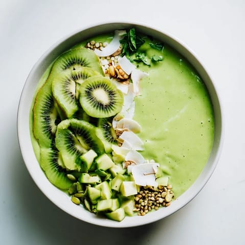 This healthy Green Smoothie Bowl features a vibrant green mixture, ready for a fresh and fruity breakfast.