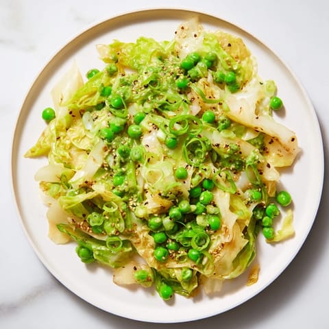 A colorful bowl of fresh Cabbage Stir-Fry, with vibrant green peas and fragrant garlic aroma.