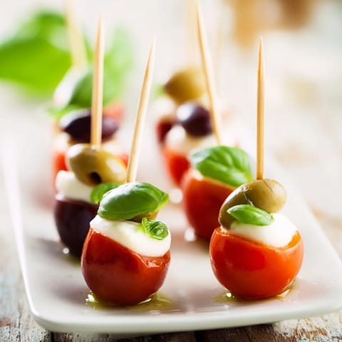 These Christmas Lights Olive and Tomato Skewers showcase vibrant cherry tomatoes and olives threaded on pretzel sticks.