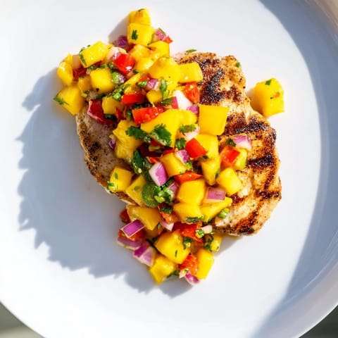 A close-up of beautifully grilled Mango Salsa Chicken, bursting with tropical flavors, perfect dinner.