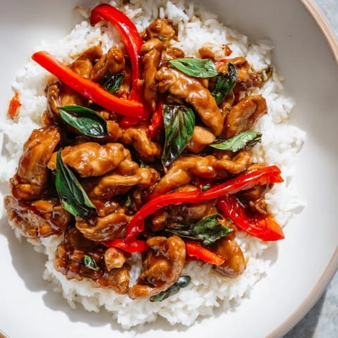 Steaming Thai Basil Chicken Bowls, a flavorful and aromatic dinner with rice and fresh basil.