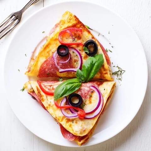 In a hot skillet, this golden Tortilla Pizza Wrap cooks to crispy perfection, revealing oozing cheese and vibrant bell pepper toppings.