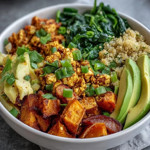 A close-up of a Tofu Scramble Vegan Breakfast Bowl with golden turmeric tofu and creamy avocado.