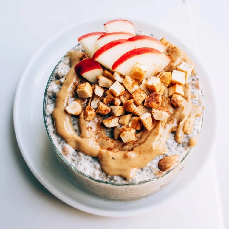 A layered bowl of Apple-Chia Pudding with a swirl of peanut butter, ideal for a quick and wholesome breakfast.