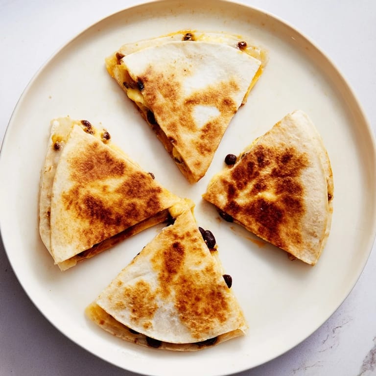 Savory, cheesy Bean & Cheese Quesadillas, folded in golden tortillas, make a fast and delicious meal.