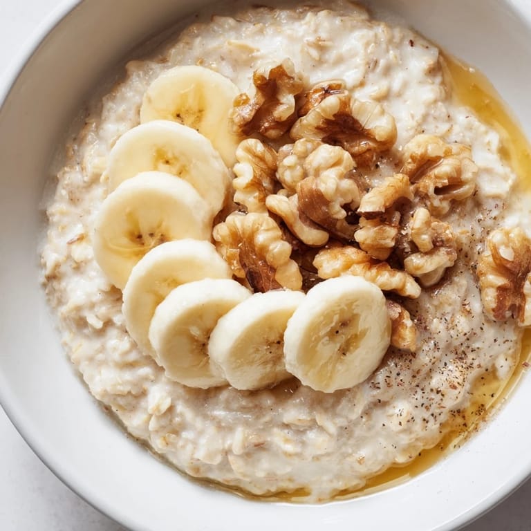 A warm, comforting bowl of Microwave Banana Oats with a sprinkle of cinnamon and chopped nuts.