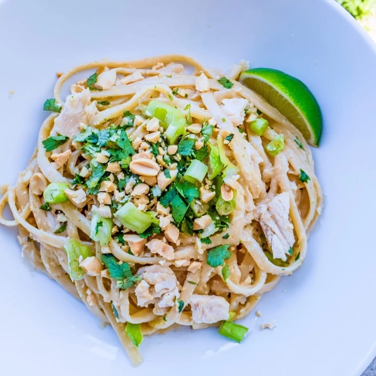 Bright, flavorful Thai Peanut Chicken Pasta with chopped peanuts and fresh cilantro for a tasty meal.
