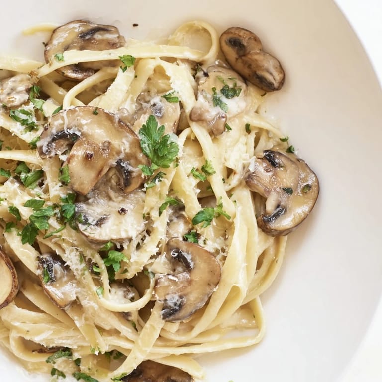 A close-up of Creamy Mushroom Alfredo, with tender mushroom slices and a luscious sauce in a warm skillet.