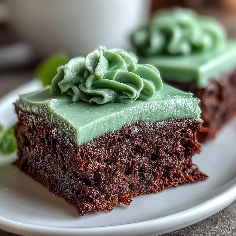 Moist chocolate brownies baked from scratch, transformed into shamrocks and topped with creamy green icing for a festive St. Patrick's Day dessert.