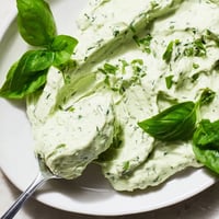 Bright green Green Goddess Salad Dip in a bowl surrounded by fresh vegetable crudités and crispy tortilla chips.