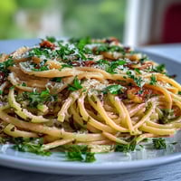 Lemon Butter Pasta with Peas and Parmesan in a creamy lemon-butter sauce, topped with grated cheese and fresh parsley.