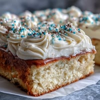 Fluffy vanilla sheet cake with creamy buttercream, decorated for graduation celebrations with festive sprinkles.