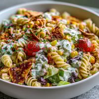 Colorful taco pasta salad with rotini, black beans, corn, and avocado in creamy taco dressing.
